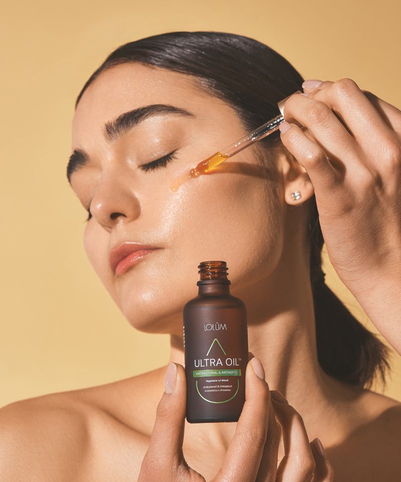 Application d'une huile végétale LOLÛM Ultra Oil au compte-gouttes sur le visage